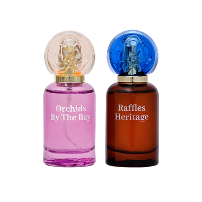 Two perfume bottles labeled 'Orchids By The Bay' and 'Raffles Heritage' on a white background.