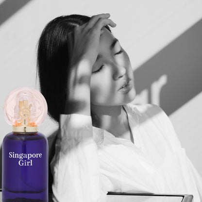 Woman with closed eyes and a bottle of 'Singapore Girl' perfume.