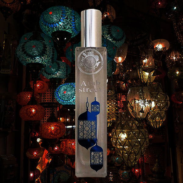 perfume bottle called arab street with blue light, in front of beautiful arabic amps