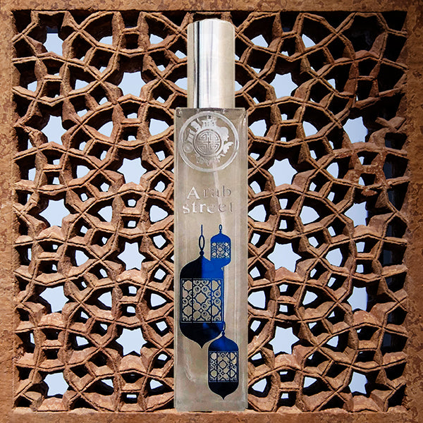 Perfume bottle with text arab street and blue color lamp icons, in from of fine stone carving