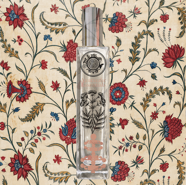 Perfume bottle with text ayurvedic essential and with decorative design on a floral patterned background
