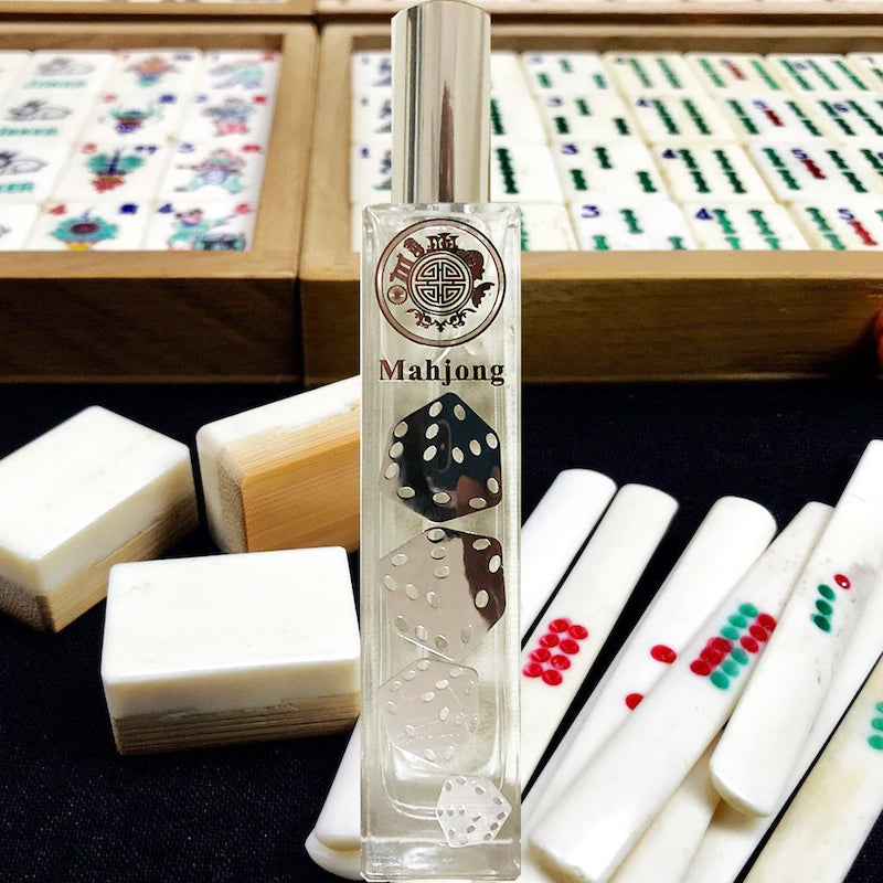 mahjong perfume bottle, on top of wooden box with play tablets inside