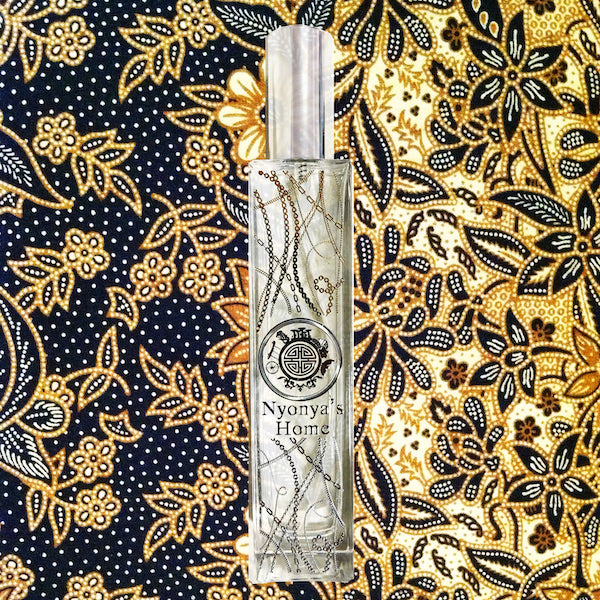 Nyonya perfume bottle in front of peranakan batik inspired by singapore themed fabric 