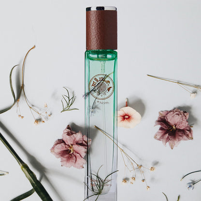 Singapore Orchid Perfume Collections by Singapore Memories called One Degree North in green bottle with flowers lying all around the scent bottle