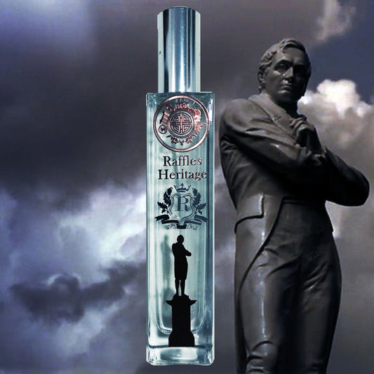 Raffles heritage glass perfume bottle with image of raffle, logo with singapore icons and word R in front of statue and clouds