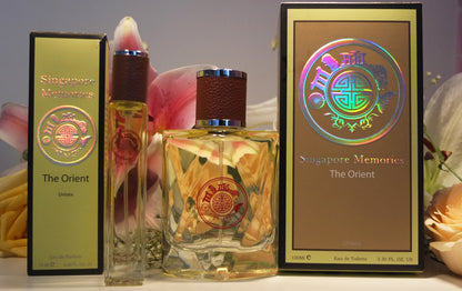 Singapore memories orchid perfume with yellow crystal bottle, one big and one small. There are yellow paper boxes behind and flower in the background