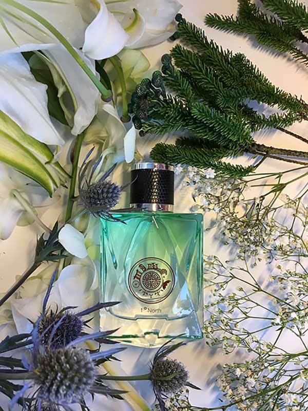 Green perfume bottle by singapore memories with decorative label on flowers and greenery
