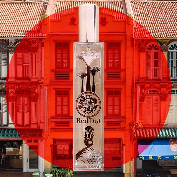 RedDot perfume bottle with a red circular overlay on a background of traditional buildings.