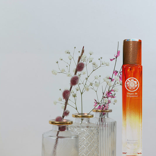 Reves De Singapour, singapore memories, revival of old perfume from 1960 in orange bottle with dry leaves in front in decorated glass reed diffuser bottles
