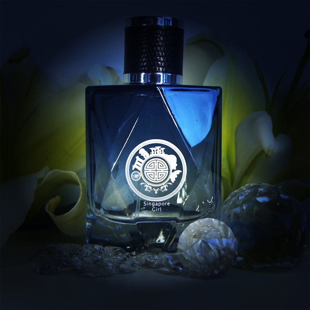 Singapore Girl perfume for her by Singapore Memories in blue color surrounded in crystal and green leaf background